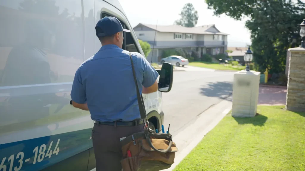 Technician carrying equipment to a Pflugerville house for drain cleaning