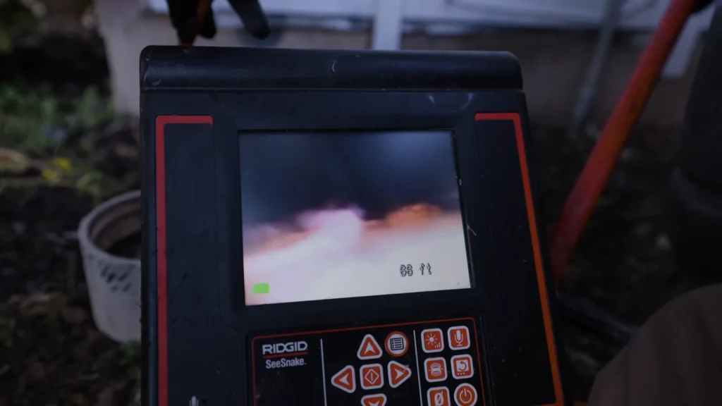 Sewer camera monitor showing live pipe footage during an inspection